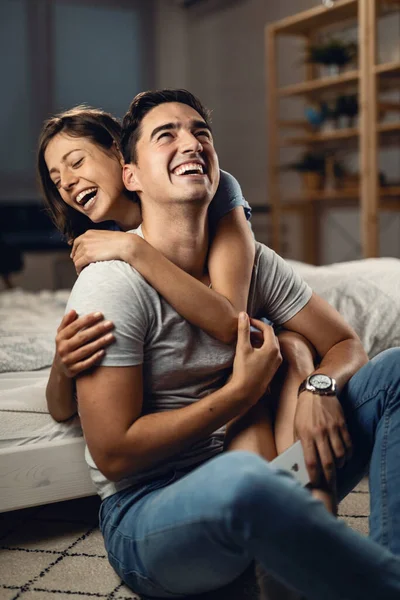 Young cheerful couple laughing about something and having fun at home.