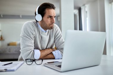 Young pensive businessman having problems and thinking while working at home. 