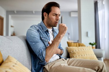 Sick man feeling chest pain and coughing at home. 
