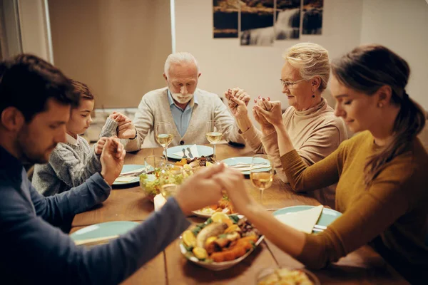 Multi Generation Family Holding Hands Praying Eyes Closed Meal Dining — Zdjęcie stockowe