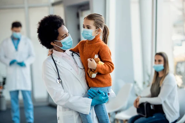 Happy Black Female Doctor Holding Little Girl While Standing Lobby — 스톡 사진