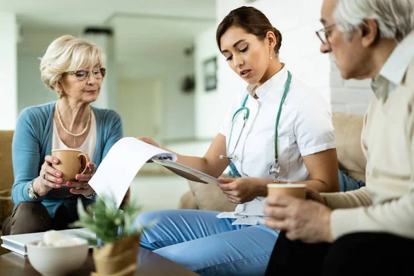 Young Healthcare Worker Senior Couple Analyzing Medical Test Results Home — Fotografia de Stock