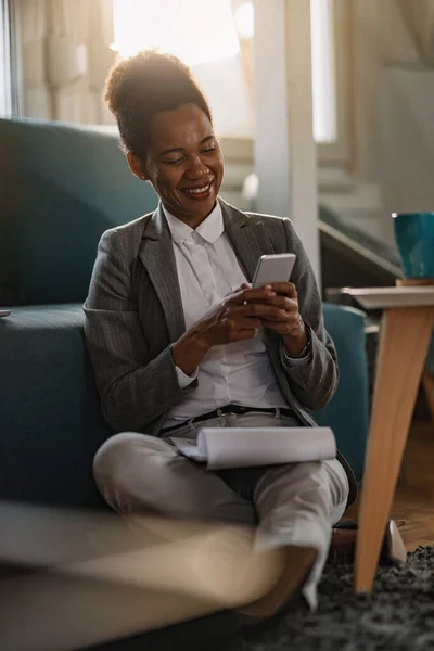 Happy Black Businesswoman Sitting Floor Using Cell Phone While Working — Stock Fotó
