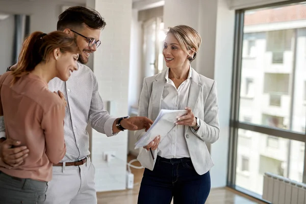 Happy Real Estate Agent Showing Couple Plans New Home — Foto Stock