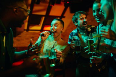 Afrikalı Amerikalı bir kadın barda arkadaşlarıyla gece geçirirken karaoke yapıyor..