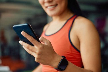 Spor yaparken cep telefonuyla mesajlaşan bayan sporcuların yakın plan fotoğrafları..