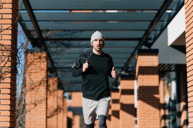 Determined young athlete running in the city. 