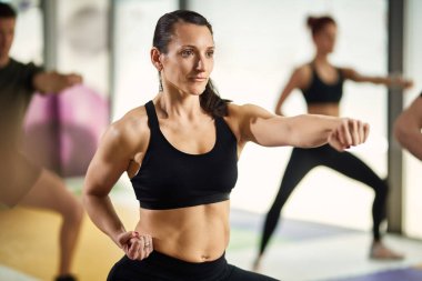 Female martial artist practicing punches while during sports training at health club.