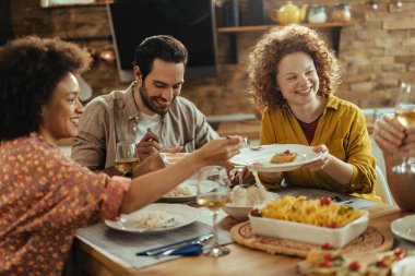 Group of happy friends enjoying while having lunch together at home. 