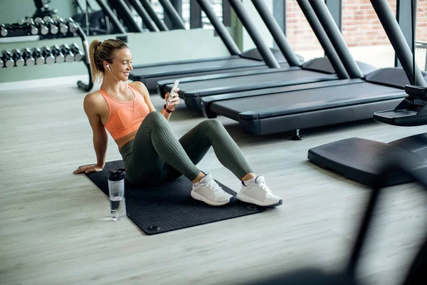 Happy Female Athlete Taking Break Exercising Text Messaging Mobile Phone —  Fotos de Stock