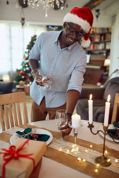 Happy Black Man Enjoying While Decorating Dining Table Christmas Celebration — ストック写真