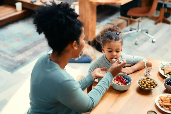 African American Little Girl Enjoying Healthy Breakfast While Mother Feeding — Foto de Stock