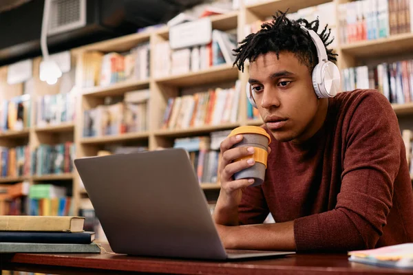 African American Student Using Laptop Drinking Coffee While Studying Library — Zdjęcie stockowe