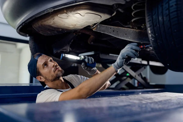 Auto Repairman Using Flashlight While Working Vehicle Workshop — Fotografia de Stock