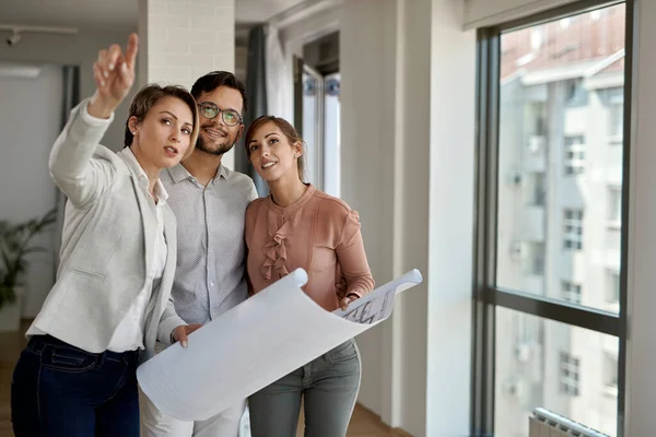 Young Couple Buying New Apartment Examining Blueprints Real Estate Agent — Stockfoto