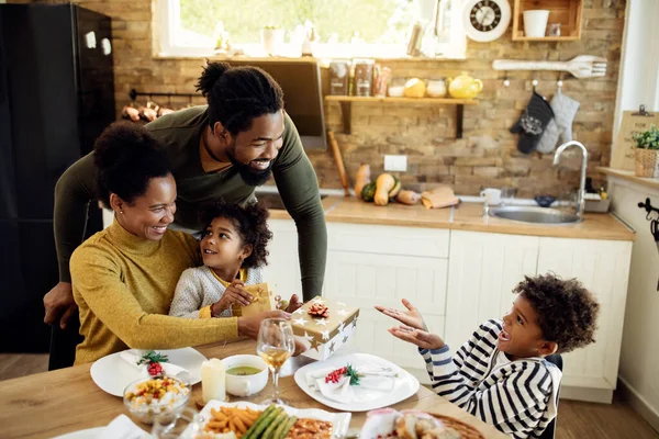 Happy Black Kids Receiving Christmas Presents Form Parents Family Lunch — Foto de Stock