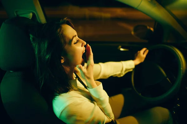 Young Woman Feeling Tired Yawning While Driving Car Night — Stockfoto