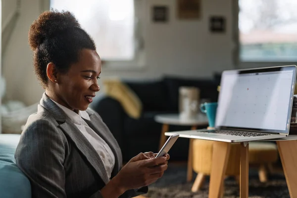 Happy African American Businesswoman Texting Smart Phone While Working Home — стоковое фото