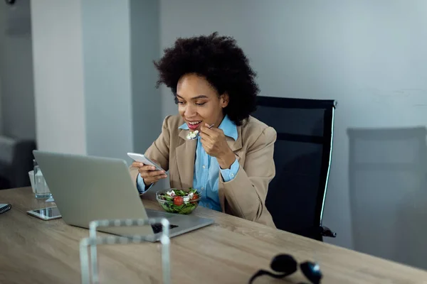 Happy African American Businesswoman Eating Salad Using Smart Phone Lunch — ストック写真