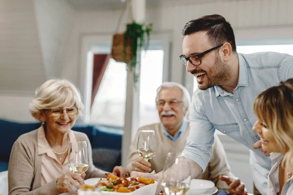 Happy Man Serving Meal While Having Lunch His Family Dining — Foto Stock