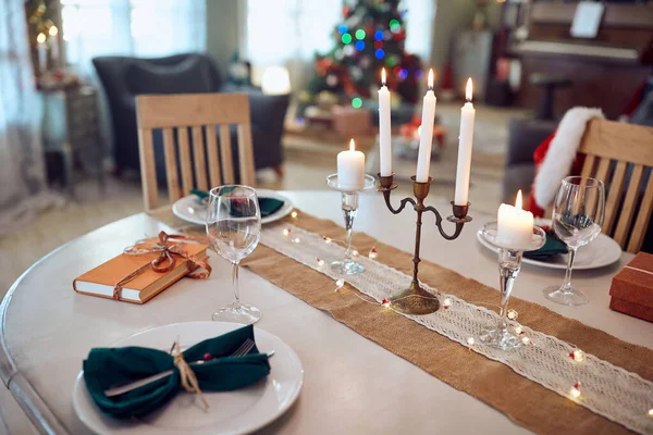 Decorated dining table and lighted candles on Christmas day at home.