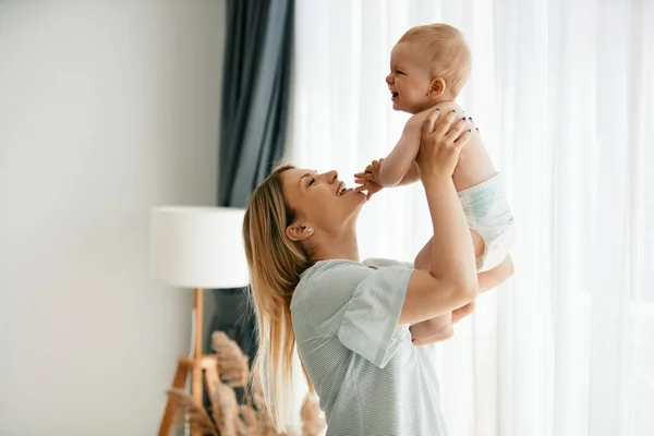 Happy Mother Trying Cheer Her Crying Baby Boy While Playing — Foto de Stock