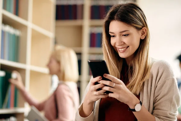 Happy Female Student Using Smart Phone University Library —  Fotos de Stock