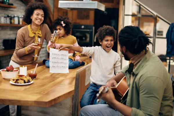 Happy Black Boy Holding Music Sheet While His Father Playing — Foto de Stock