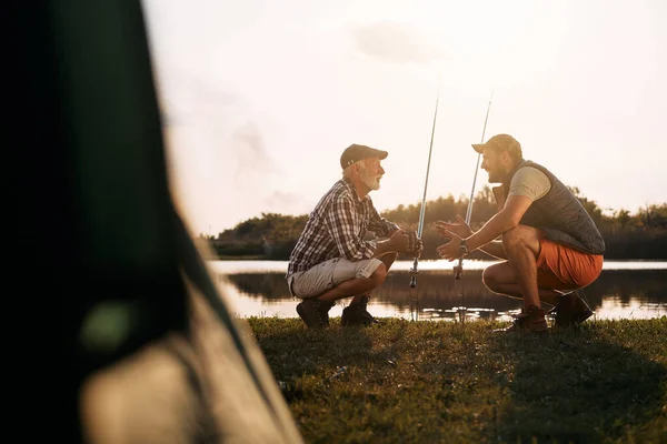 Happy Man Talking His Senior Father While Fishing Lake Sunset — ストック写真