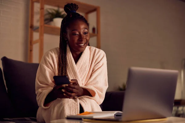 Young African American Woman Bathrobe Texting Mobile Phone While Reading — стокове фото