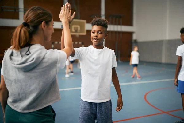 Happy Black Elementary Student His Sports Teacher Giving High Five — Foto de Stock