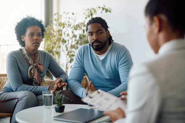 African American couple talking to financial advisor during a meeting in the office.