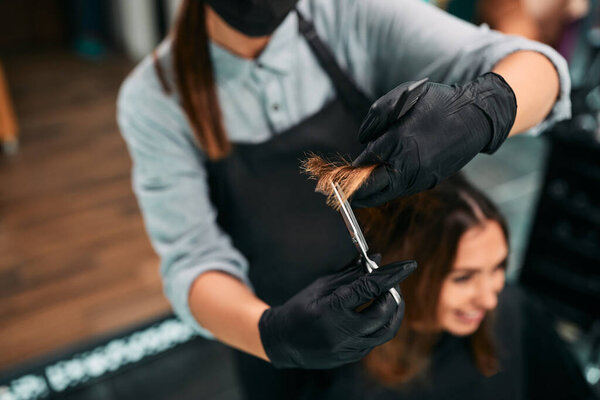 Close-up of hairdresser cutting woman's hair in a salon.