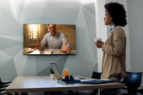 African American businesswoman communicating with a colleagues via conference call in the office.