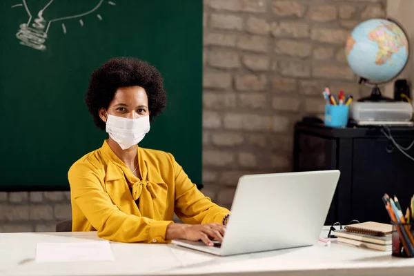 Black Female Teacher Using Laptop Wearing Protective Face Mask Classroom — Foto Stock