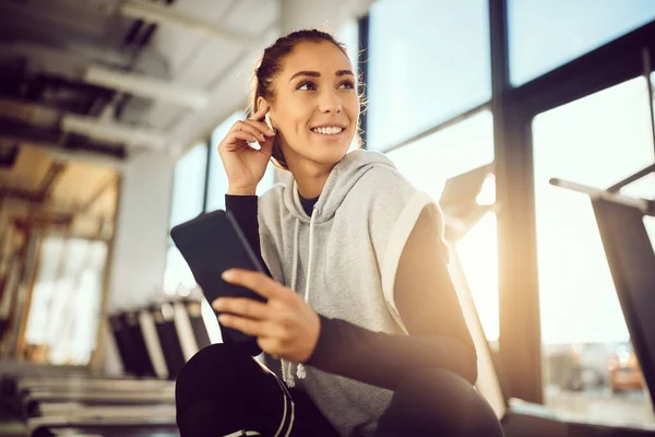 Young Female Athlete Listening Music Earphones Using Mobile Phone While — 图库照片