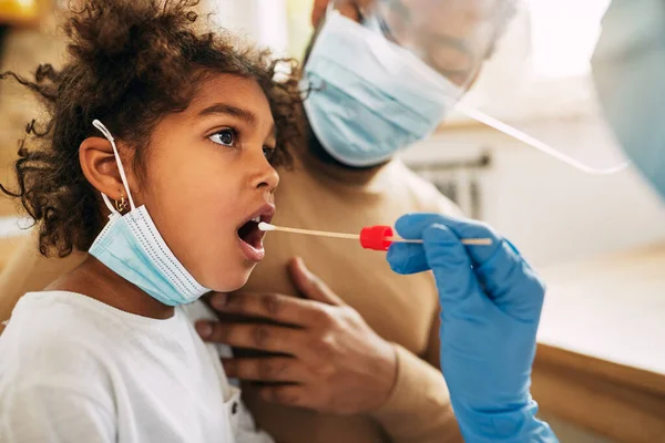 Black little girl having PCR test during coronavirus pandemic. 
