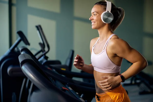 Young Happy Athletic Woman Wearing Headphones While Jogging Running Track — Zdjęcie stockowe