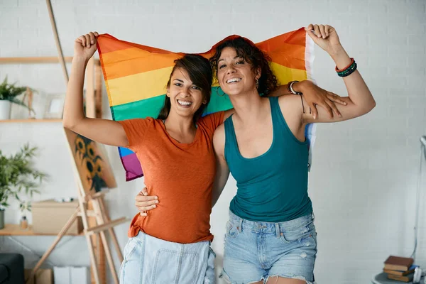 Young Happy Lesbian Couple Having Fun Holding Rainbow Flag Home —  Fotos de Stock