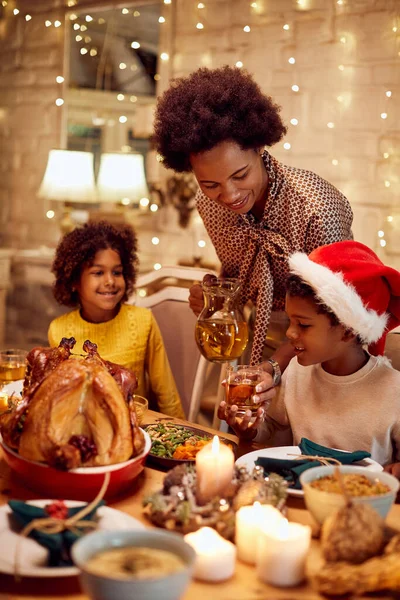 Happy Black Mother Giving Juice Her Children While Eating Christmas — ストック写真