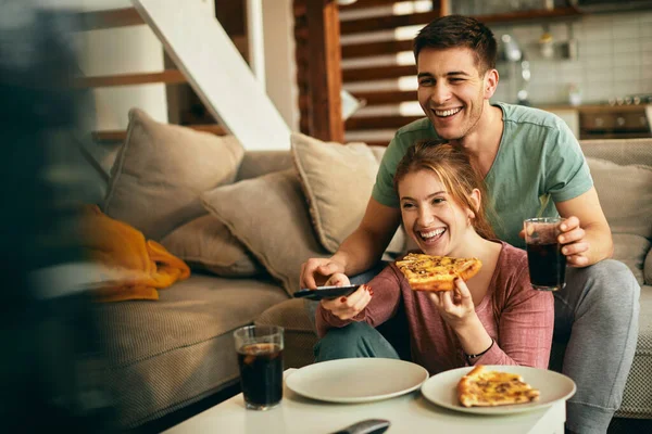 Young Couple Having Fun While Eating Pizza Watching Living Room — стоковое фото