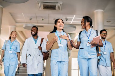 Happy Asian nursing student laughing and having fun while talking to her friends at medical university.