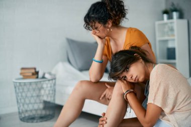 Young lesbian woman and her girlfriend feeling frustrated after an argument at home.