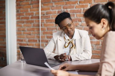 African American human resource manager talking to female job applicant during a meeting in the office.