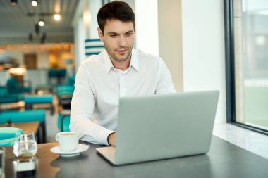 Businessman working on laptop while sitting in a cafe,
