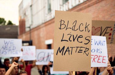 Unrecognizable person holding a placard with Black Lives Matter inscription during demonstration against racism and police brutality. 