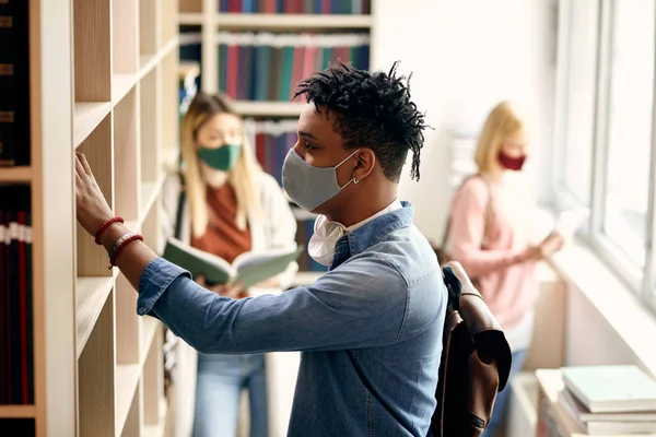 African American University Student Taking Book Bookshelf Library Wearing Face — Foto Stock