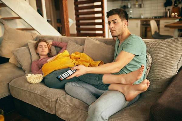 Young Man Using Remote Control Changing Channels While His Girlfriend — Φωτογραφία Αρχείου