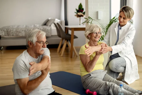 Senior couple exercising at home with help of physical therapist at home.