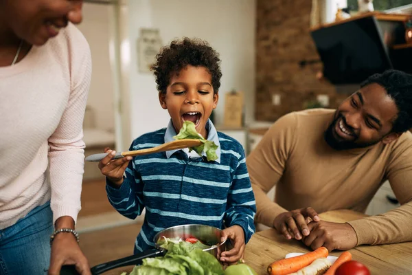 Happy Black Boy Tasting Salad While Preparing Healthy Meal Parents — Foto de Stock